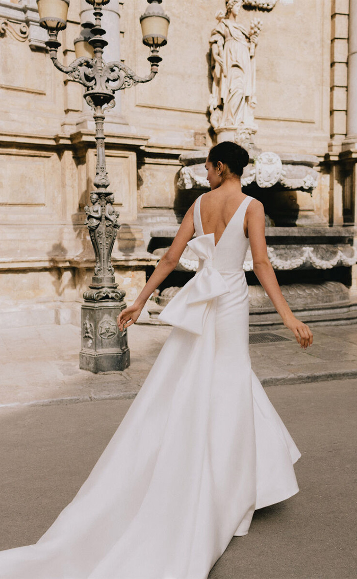 modern V back bridal gown with bows on back